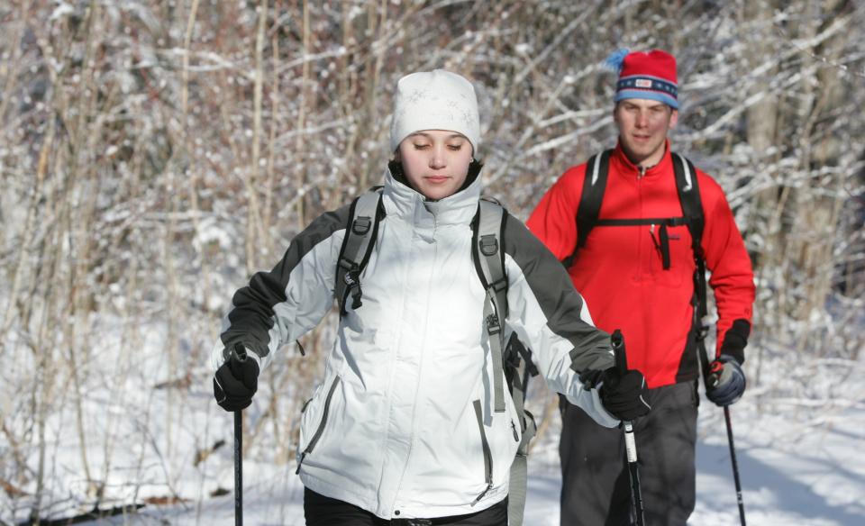 a beginner x-country skiier with a trainer following her