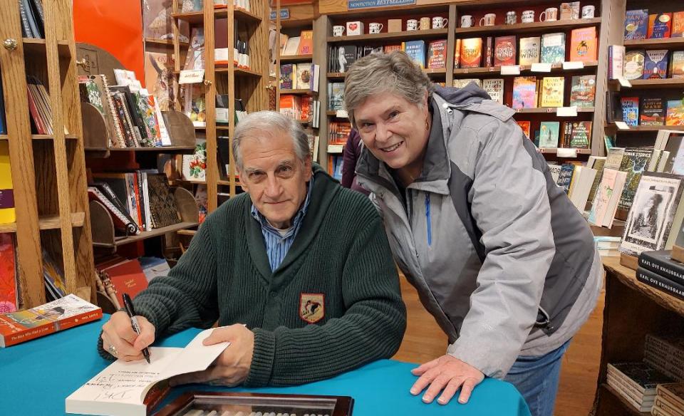 A photo of Phil Bayly and a fan as he signs her book