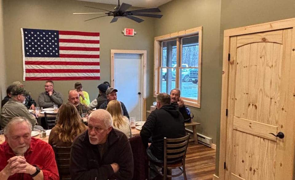 a room full of people sitting at tables in a room at Axes and Irons