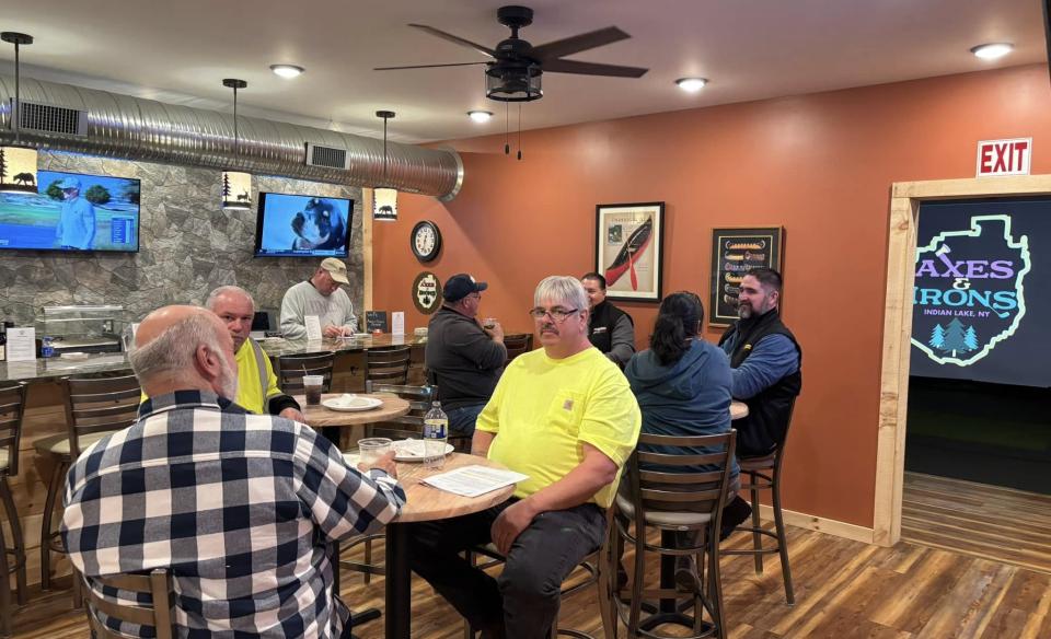 a room full of people sitting at tables in a room at Axes and Irons