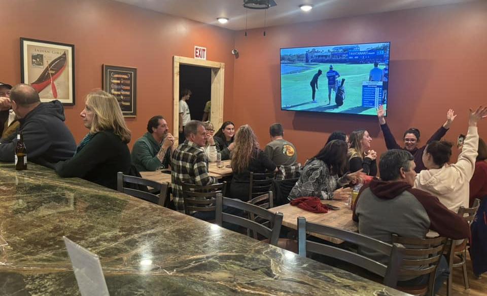 The main room of tables with many people sitting and enjoying their time