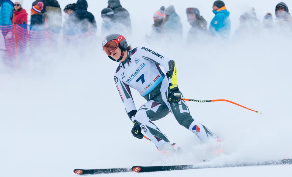 a slalom skiier in all their racing gear skiing down the hill