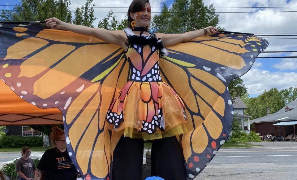 A lady dressed in a monarch costume on stilts