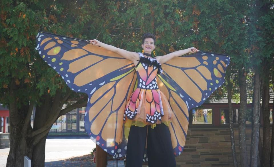 A lady dressed in a monarch costume on stilts