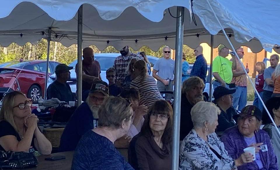 people sitting under a tent listening to the live music