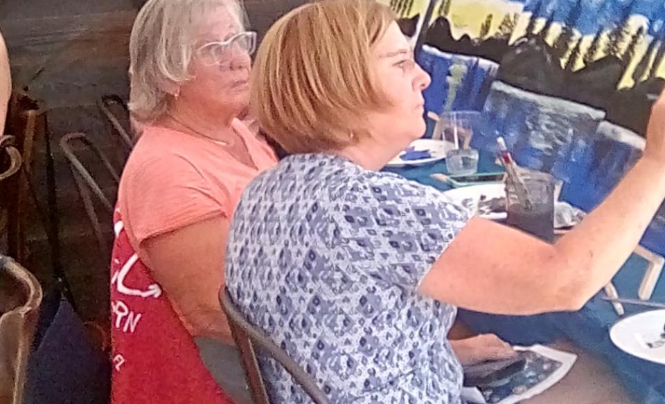 Two ladies sitting at a table painting their canvas at a paint n sip at the lemon tree brewery