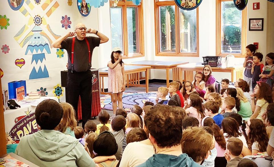 magician dave performing in front of an audience of children