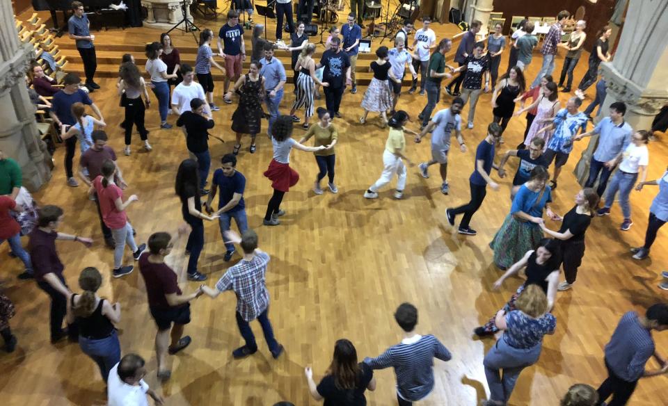 a gymnasium of people contra dancing