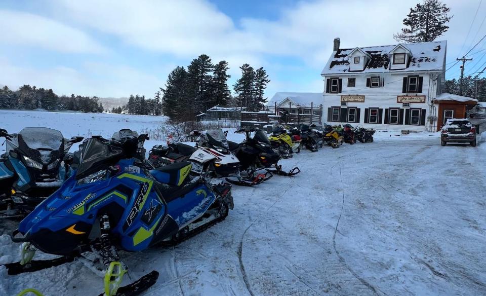 An exterior photo of the diner with a line of snowmobiles parked outside