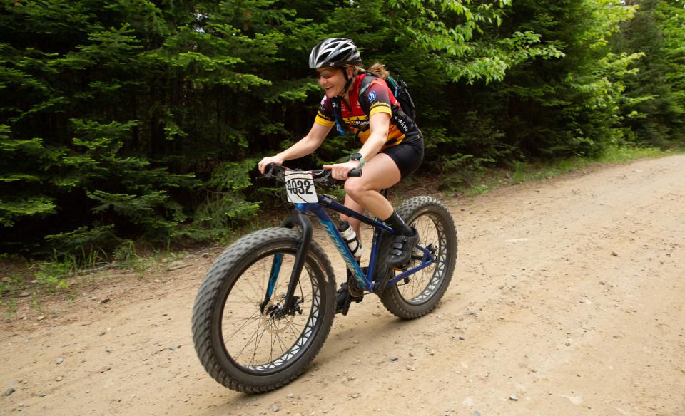 Cyclists in colorful jerseys and helmets gather at the starting line of the Black Fly Challenge in the Adirondacks.