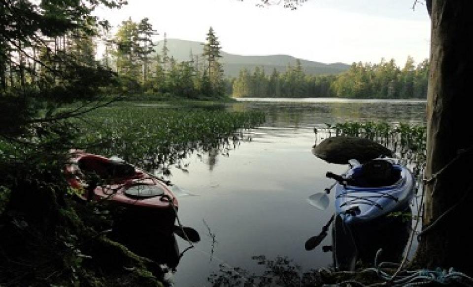 Two kayaks sit on the shore of Lake Durant