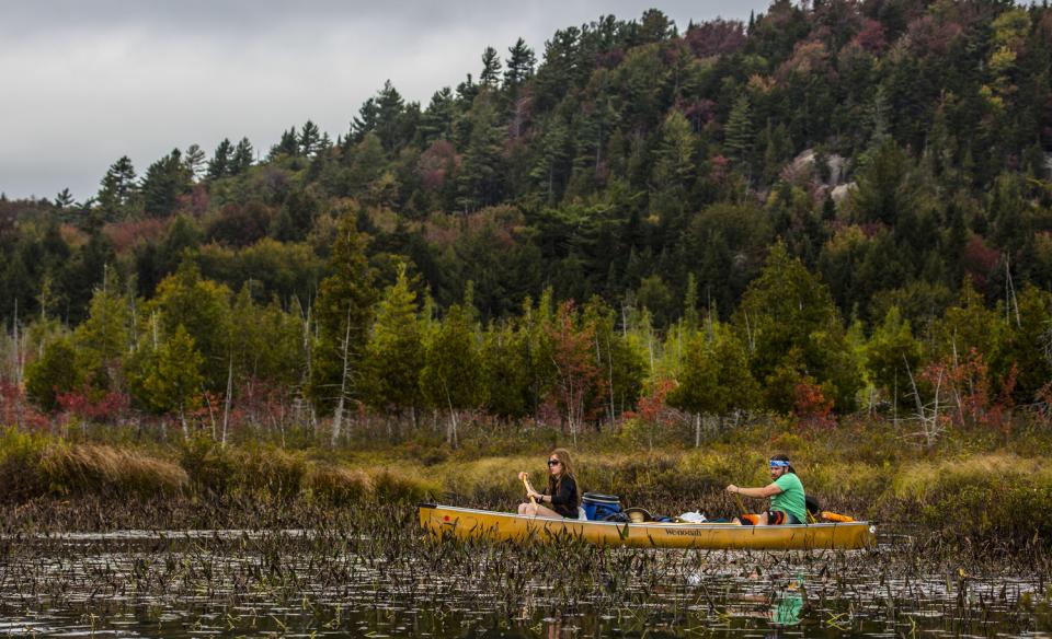 A C2 canoe in a shallow river in the fall