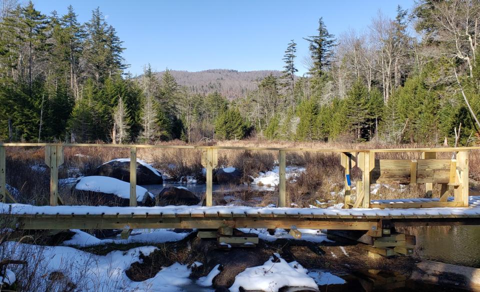 A wooden bridge lightly covered in snow