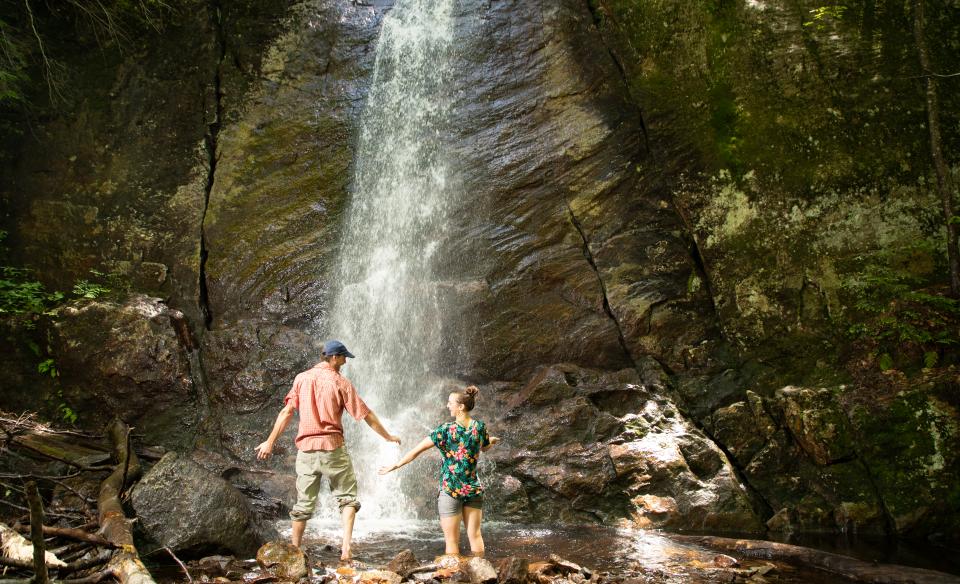 Two people at the base of Cascade Lake Falls