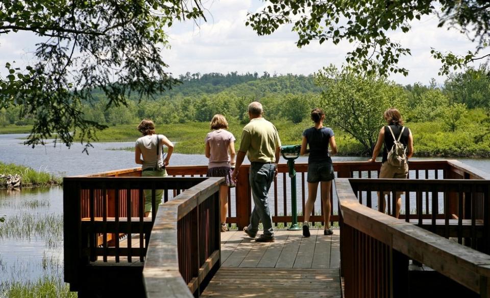 A family gazes out at the water from a large waterside structure