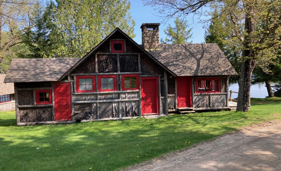 A red and brown cabin with log detailing.