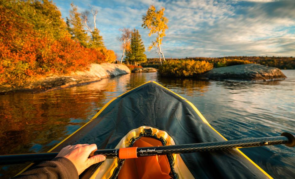 A first person view of paddling a pack raft during sunset.