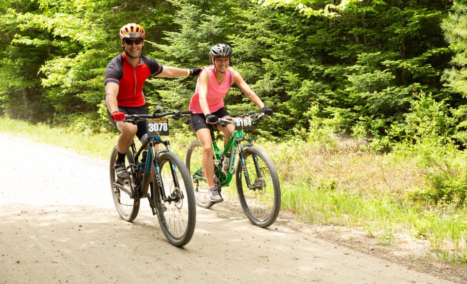 A couple bikers pedaling down a dirt road