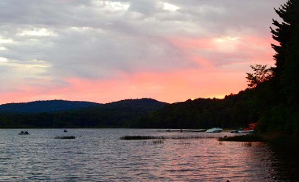 A sunset from a campground by the water