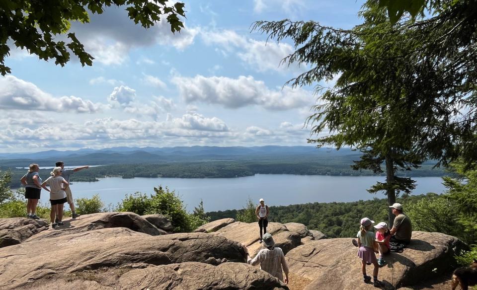 People at an overlook on a cliff with a view of the water