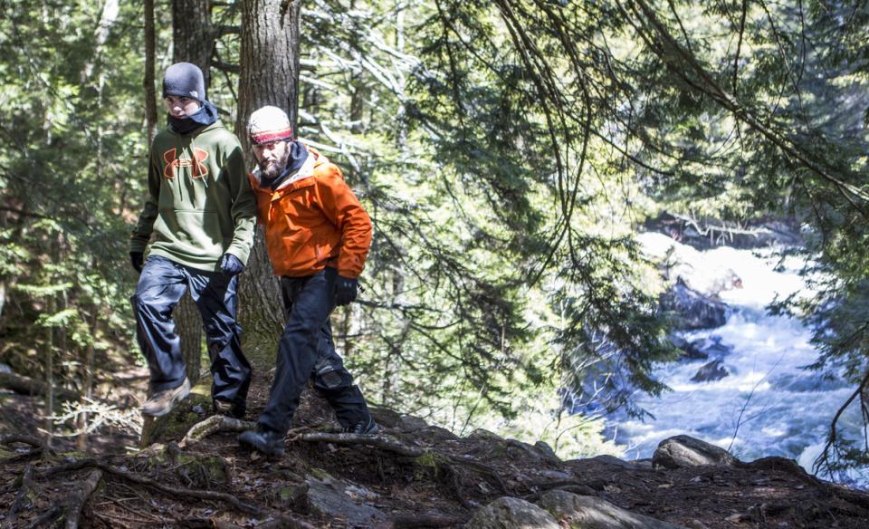 Two males hiking with Auger Falls' spring run behind them