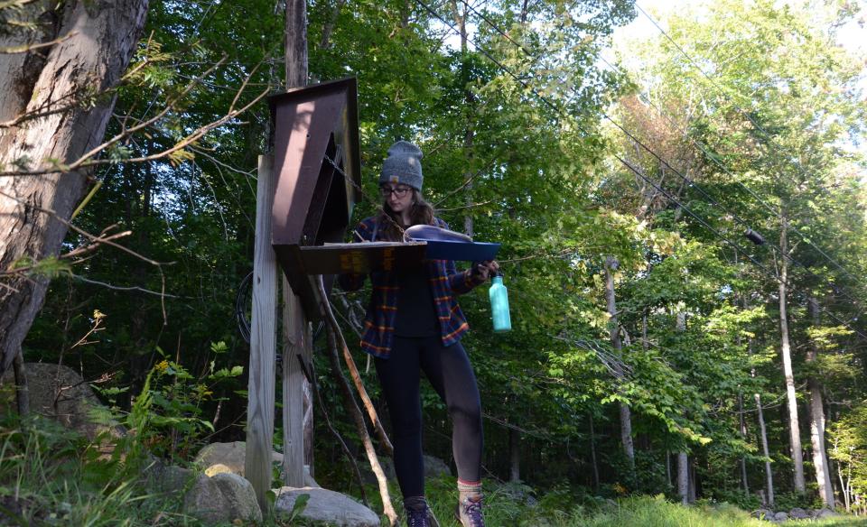 A hiker signs into the register for Castle Rock