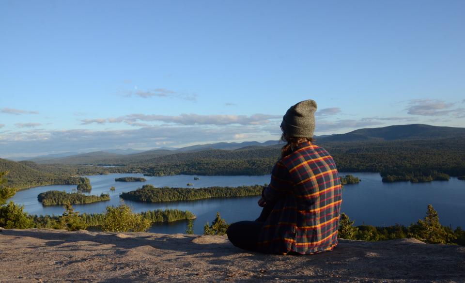 A hiker on top of Castle Rock, with a large lake in view