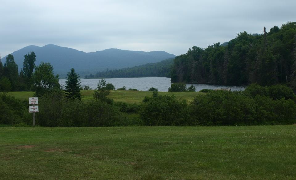 A small lake nestled amongst mountains and green trees